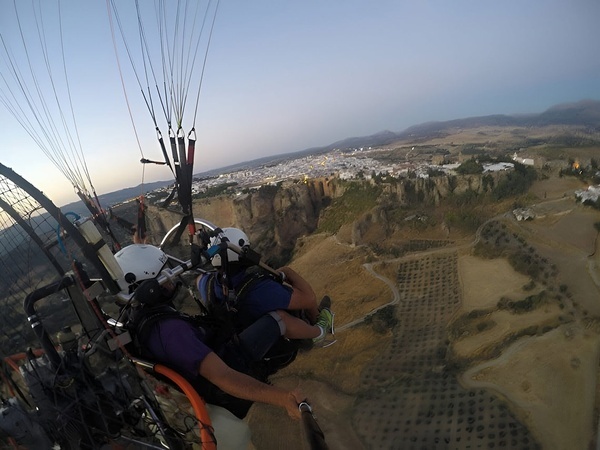 un par de paracaidistas están volando por encima de una ciudad