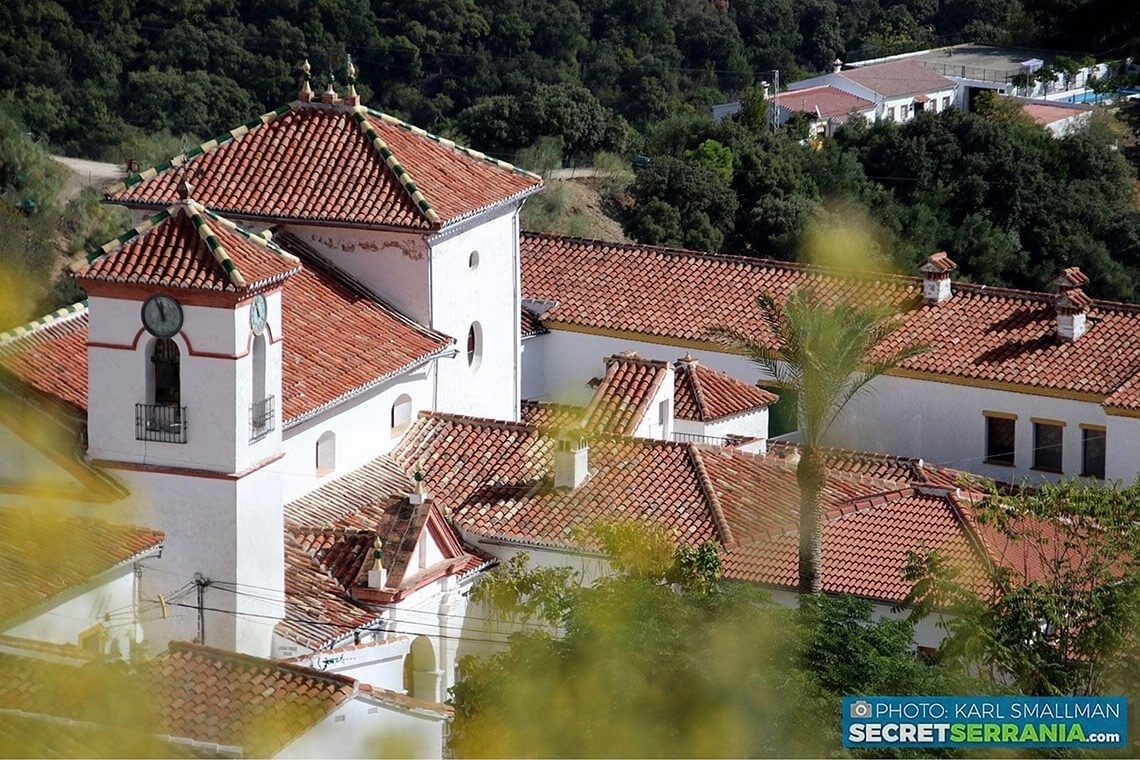 a white building with red tile roofs and a clock tower