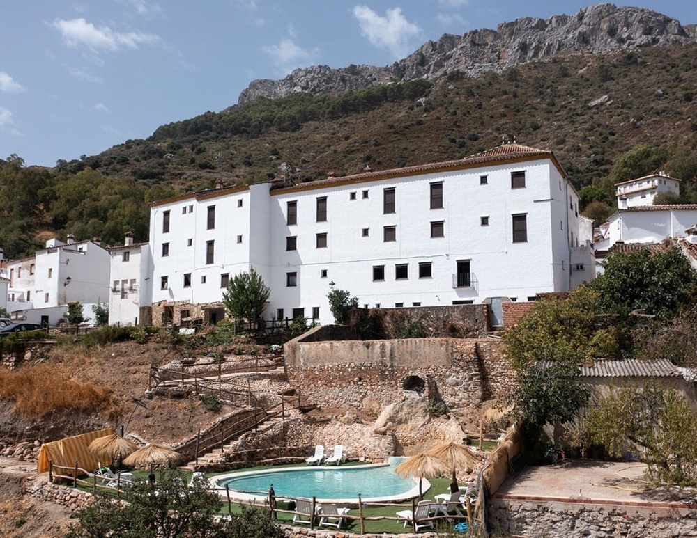 un gran edificio blanco con una piscina al frente