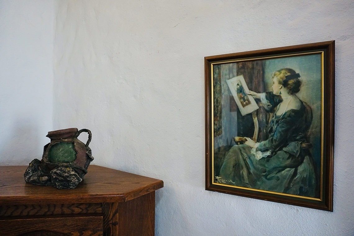 una pintura enmarcada de una mujer mirando un cuadro