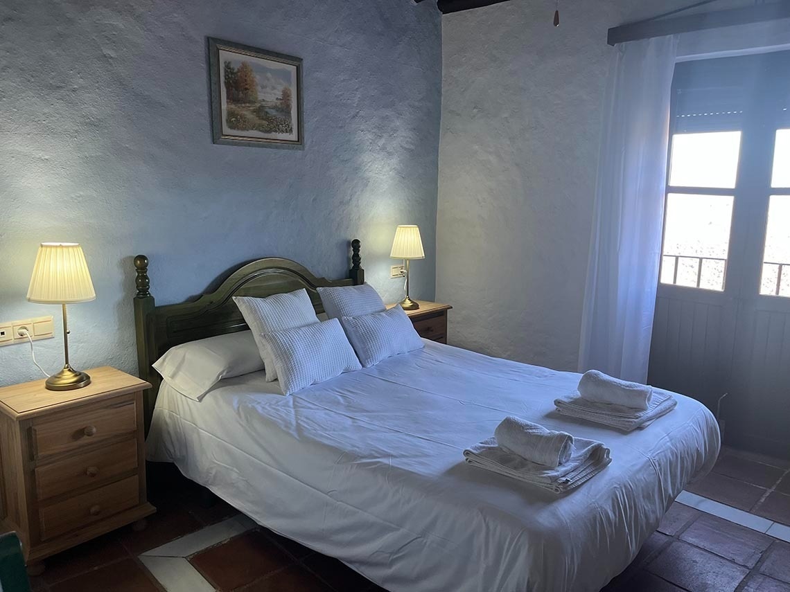 a bedroom with a painting on the wall above the bed