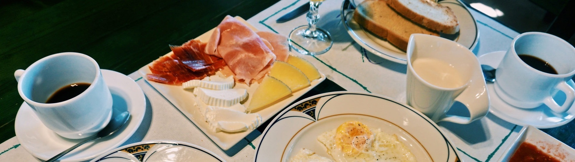 una mesa con platos de comida y tazas de café