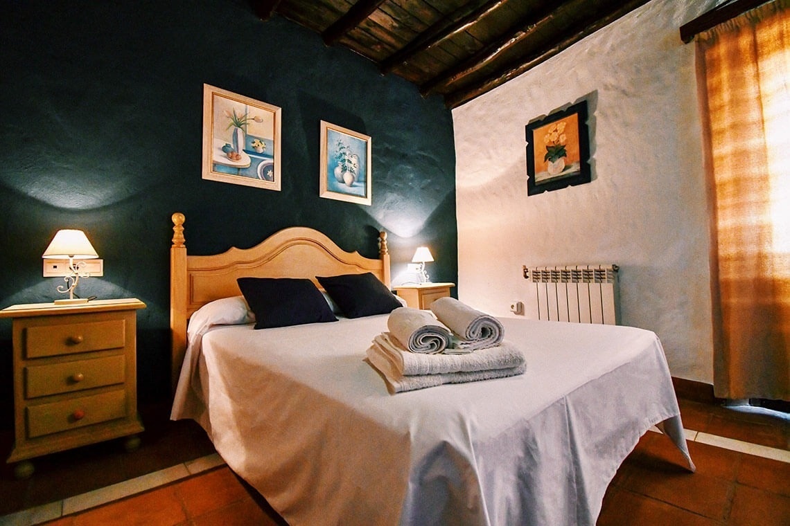 una habitación con una cama y dos mesitas de noche
