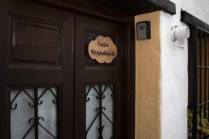 una puerta con un letrero de madera que dice casa benadalid