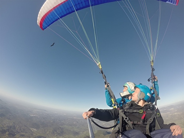 un parapente azul y rojo con dos personas en él