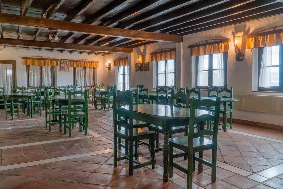 un restaurante con mesas y sillas verdes y un techo de madera