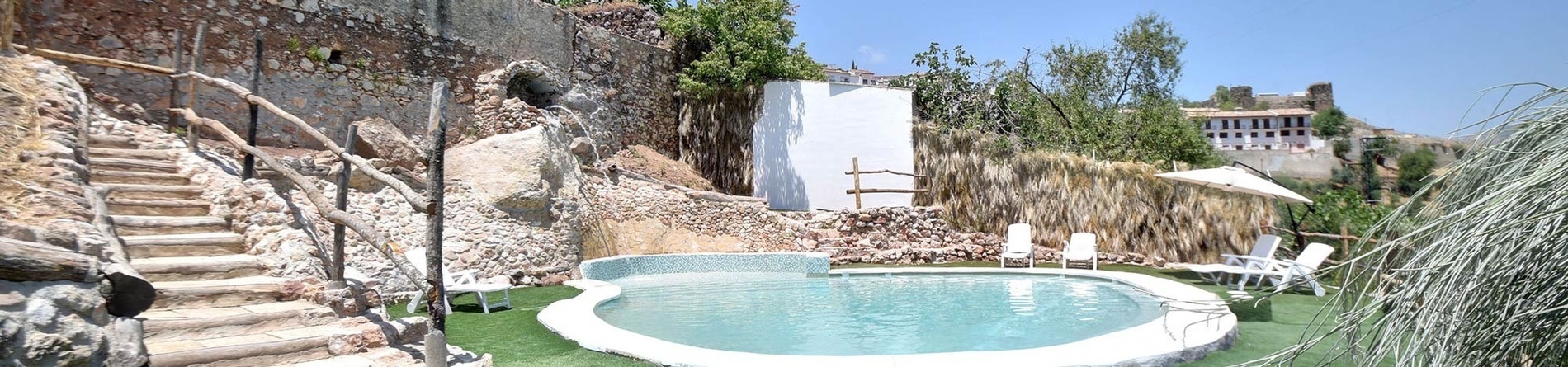 una piscina rodeada de escaleras y sillas con un edificio en el fondo