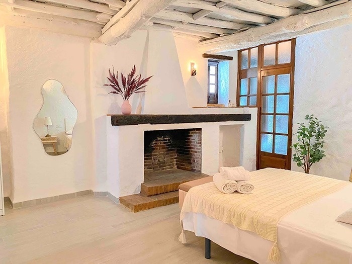 una habitación blanca con una cama y una chimenea