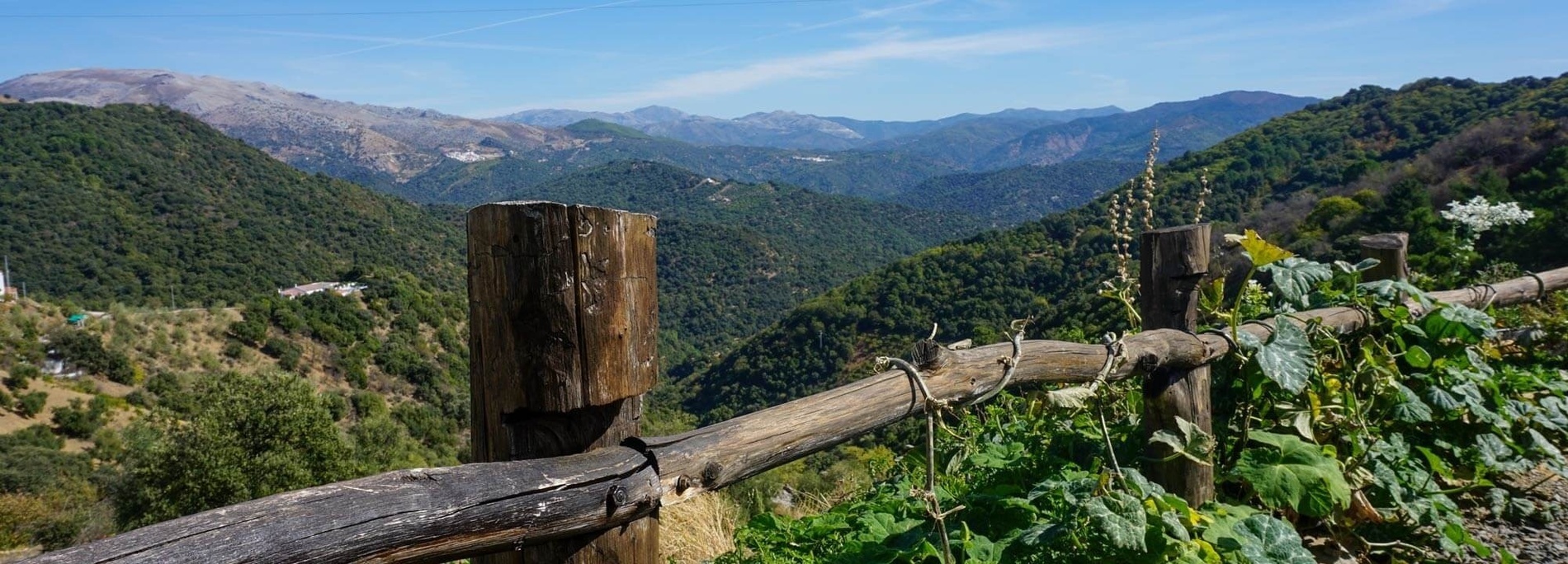 una cerca de madera con una vista de las montañas en el fondo