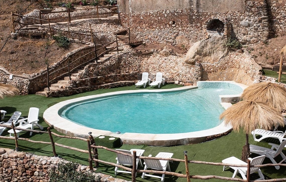 a large swimming pool surrounded by chairs and umbrellas