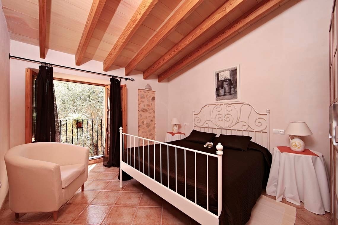 un dormitorio con una cama blanca y una silla blanca