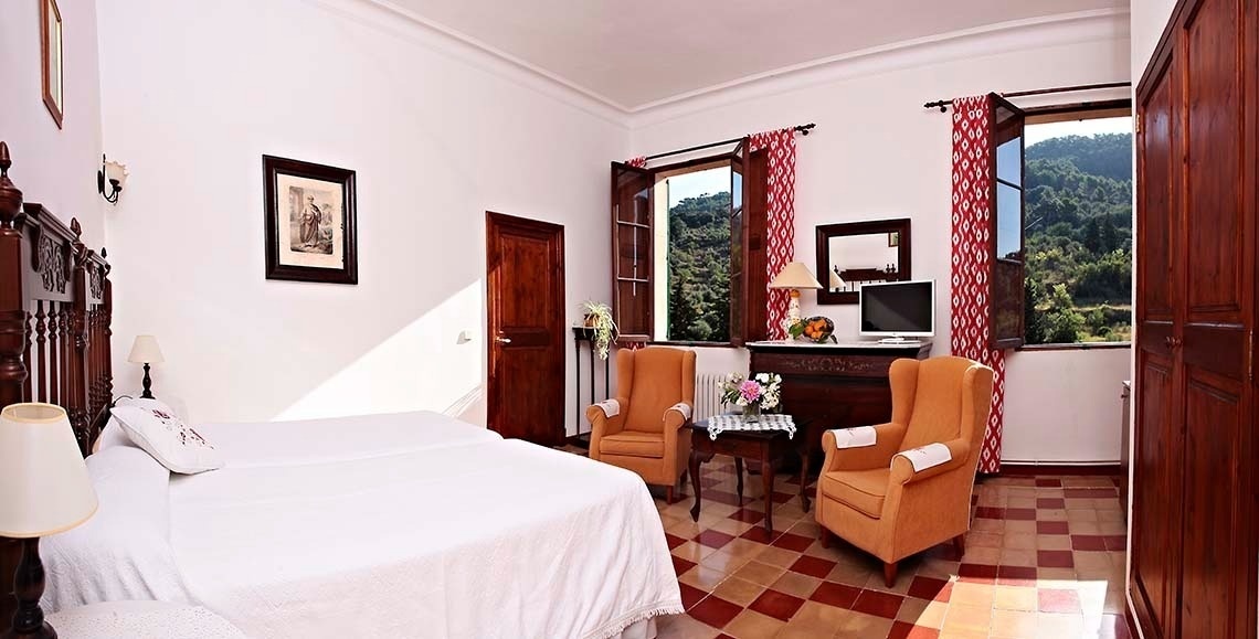 una habitación con dos camas , dos sillas , una mesa y una televisión