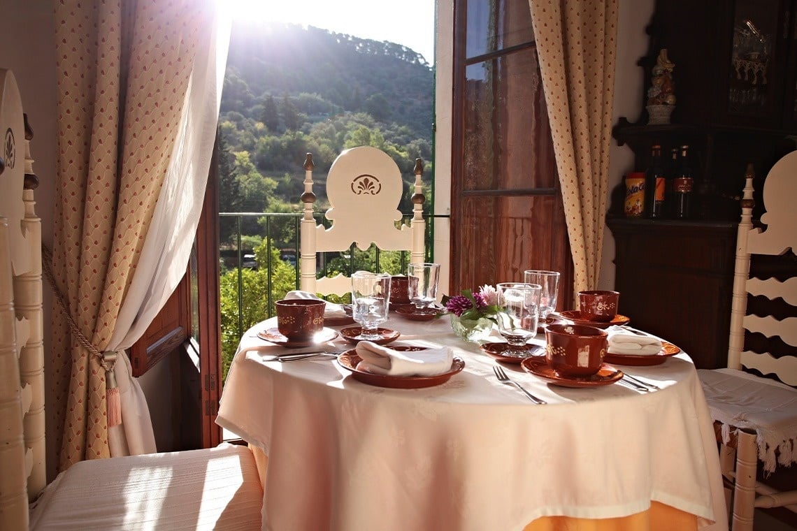 una mesa con platos y copas frente a una ventana