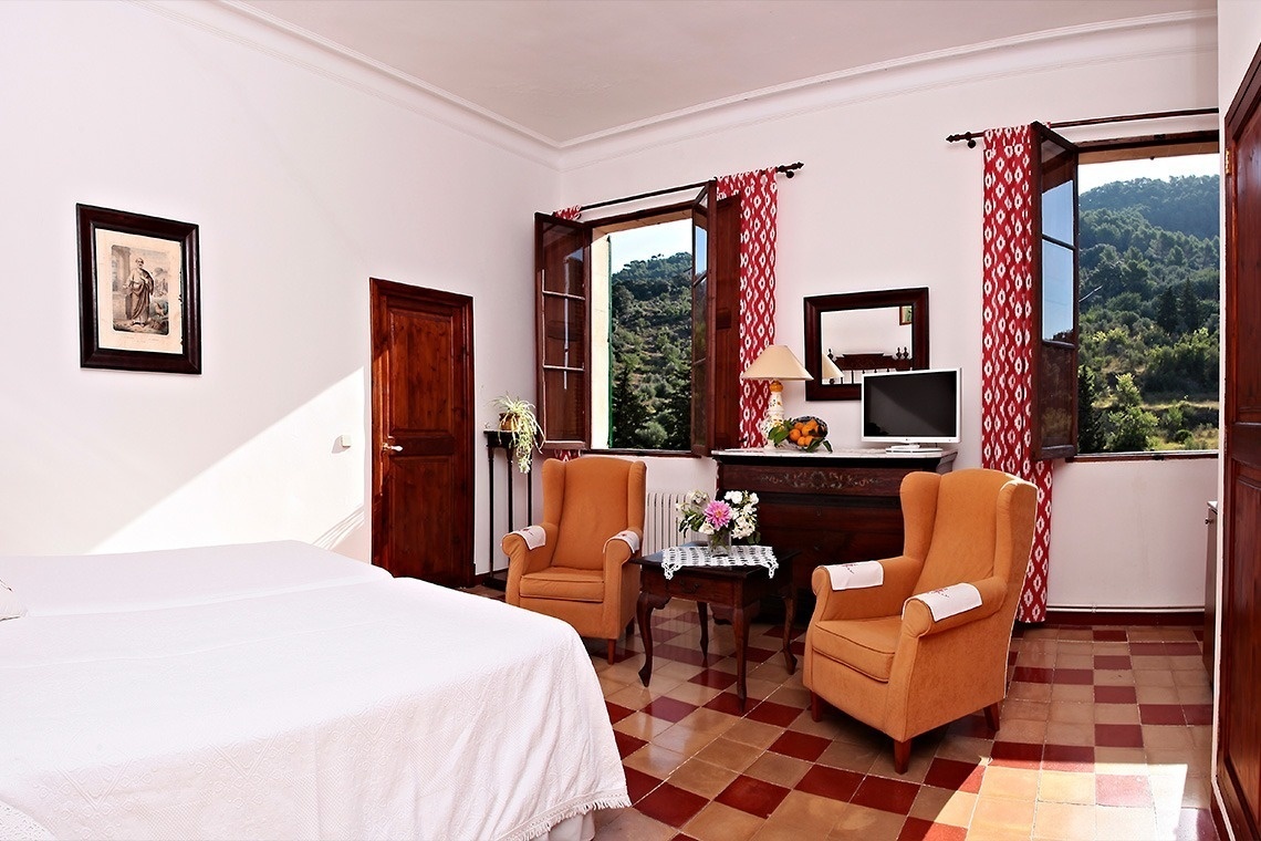 una habitación con dos camas , dos sillas , una mesa y una televisión