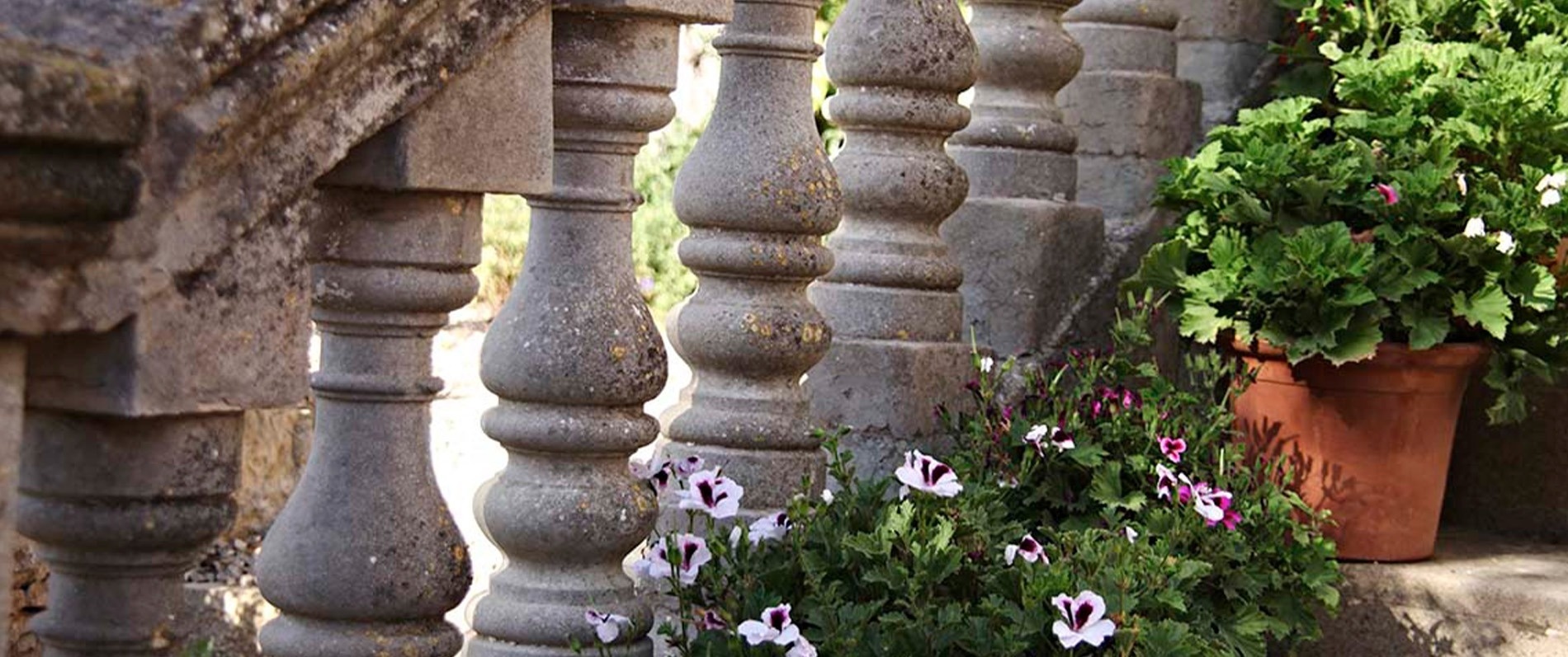 un par de columnas de piedra junto a una maceta de flores