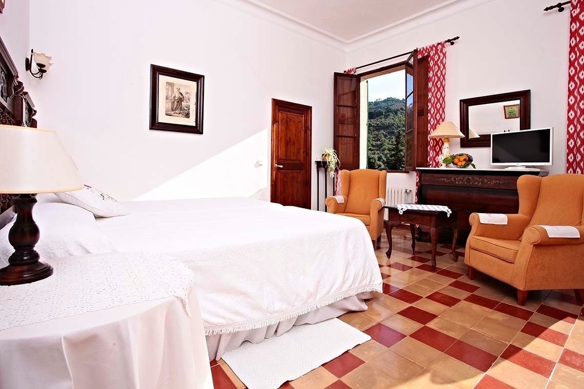 una habitación con una cama y dos sillas y una televisión