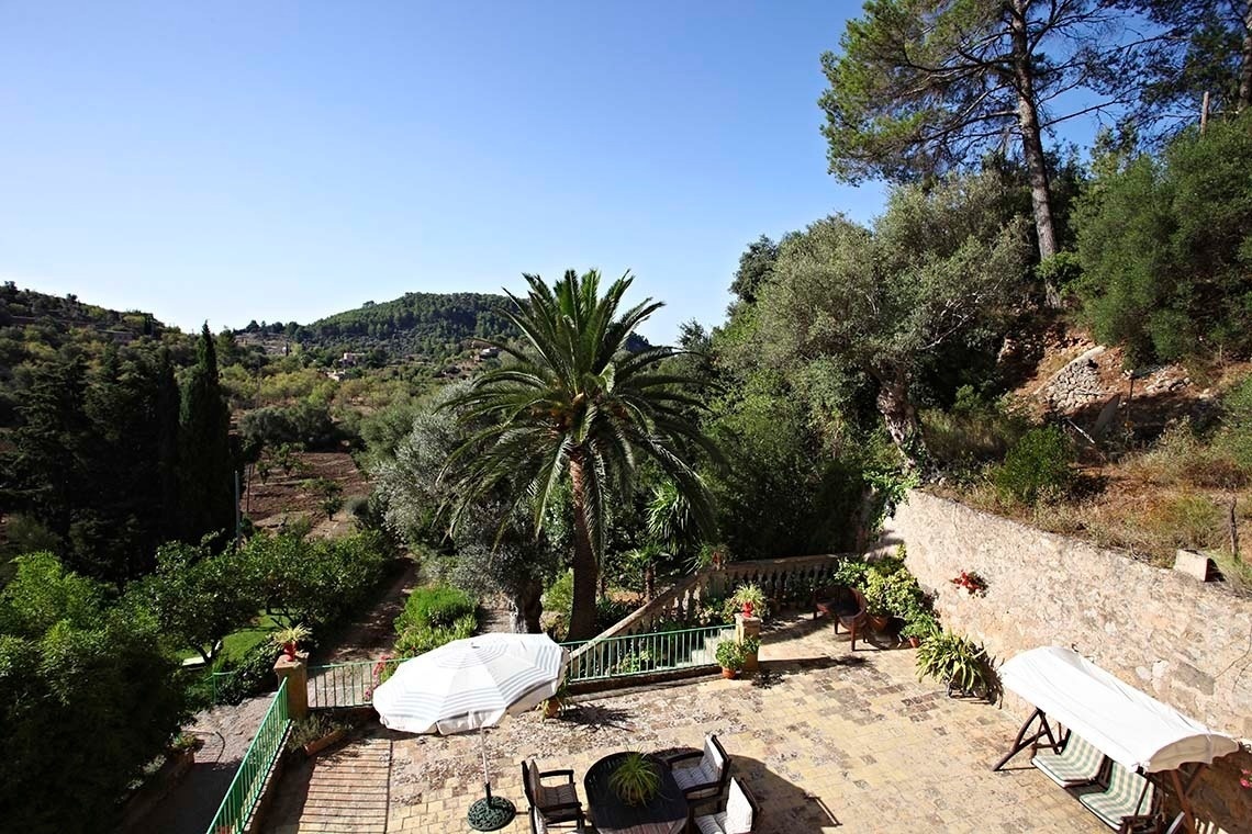 un patio con una mesa y sillas y un paraguas
