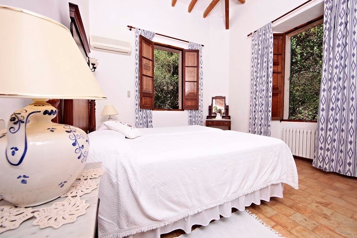 un dormitorio con dos camas y una lámpara azul y blanca