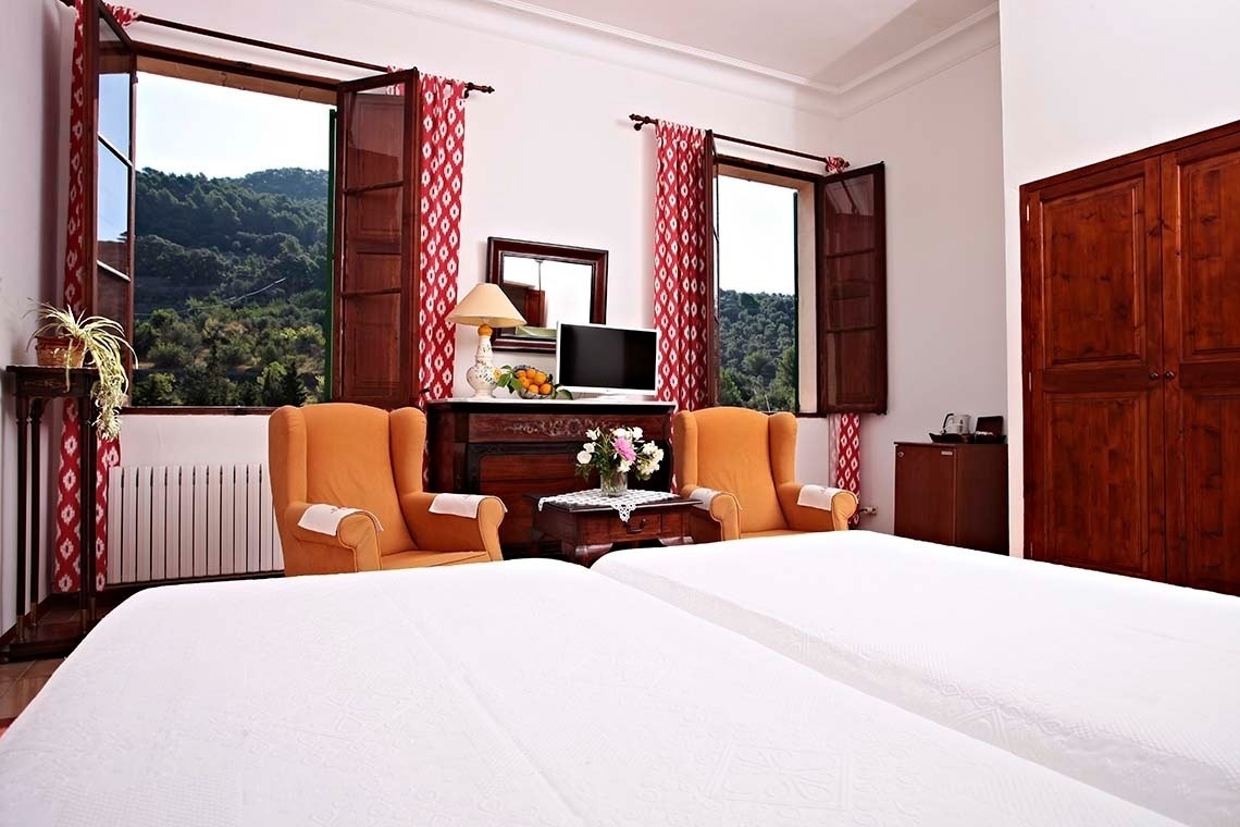 una habitación con dos camas , dos sillas y una televisión