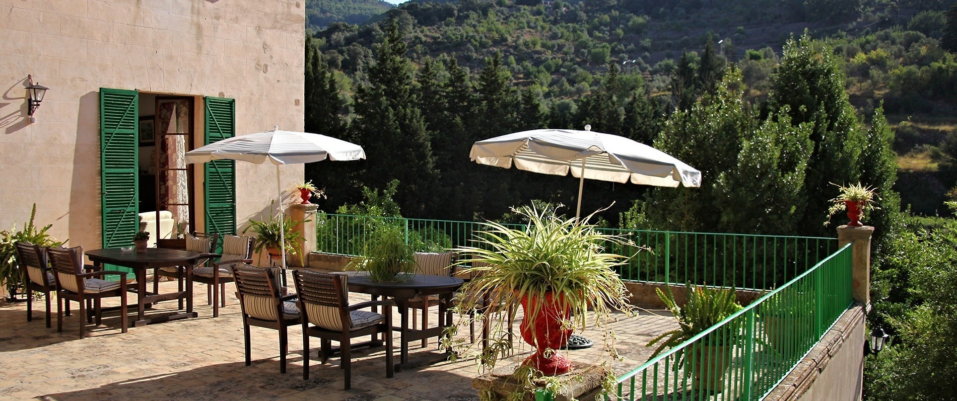 una terraza con mesas y sillas y dos sombrillas