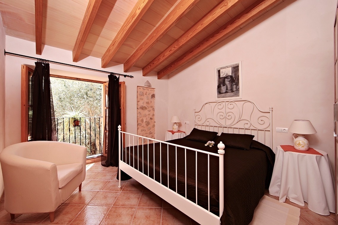 un dormitorio con una cama blanca y una silla blanca