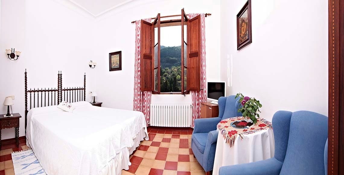 una habitación con una cama y dos sillas azules