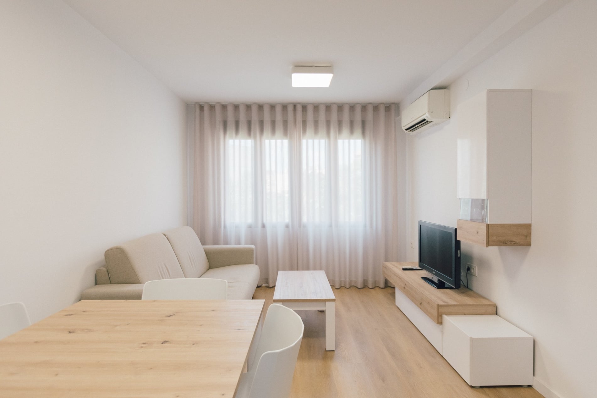 una habitación con un sofá y una televisión en la pared