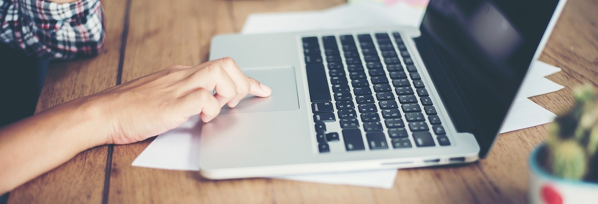 a person is typing on a laptop with the shift key visible