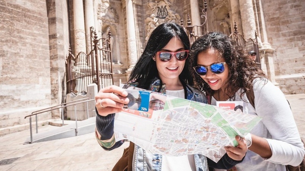 two women looking at a map with a card that says 72h on it