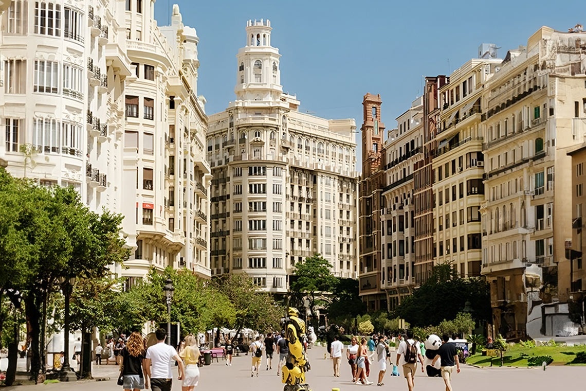 un grupo de personas caminan por una calle llena de edificios