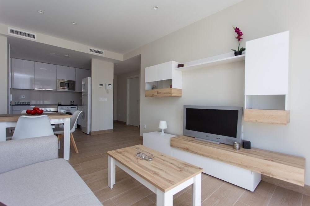 una sala de estar con una televisión y una mesa de madera