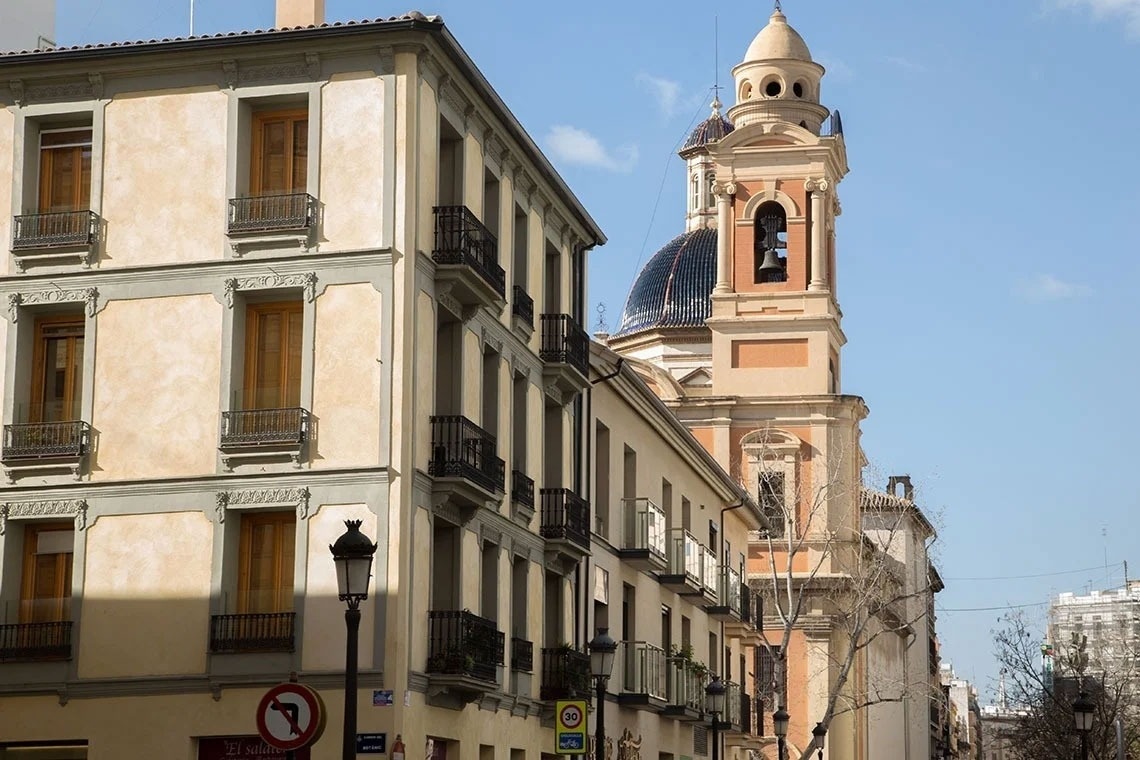 un edificio con balcones y una torre en el fondo