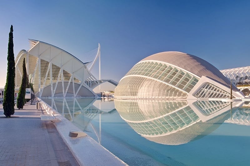 un gran edificio blanco se refleja en el agua