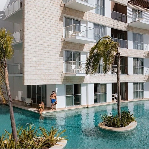 a man stands on a balcony overlooking a swimming pool
