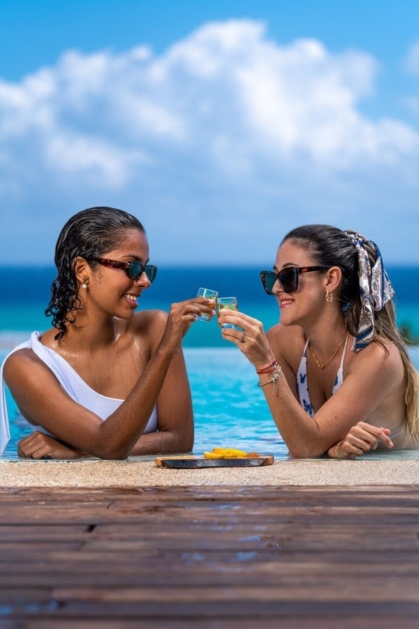 a woman sits on a pier looking at the ocean