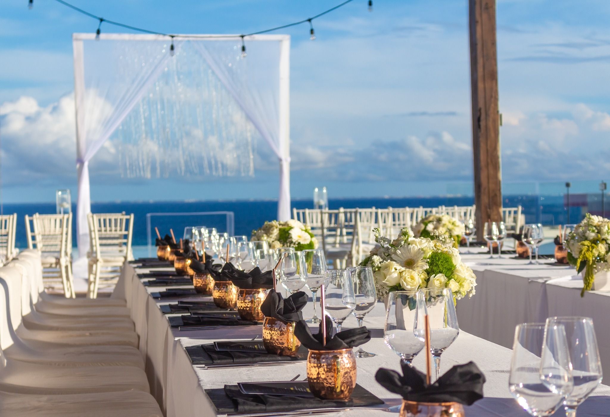 Inspiración de ceremonia rooftop o terraza con detalles tropicales elegantes