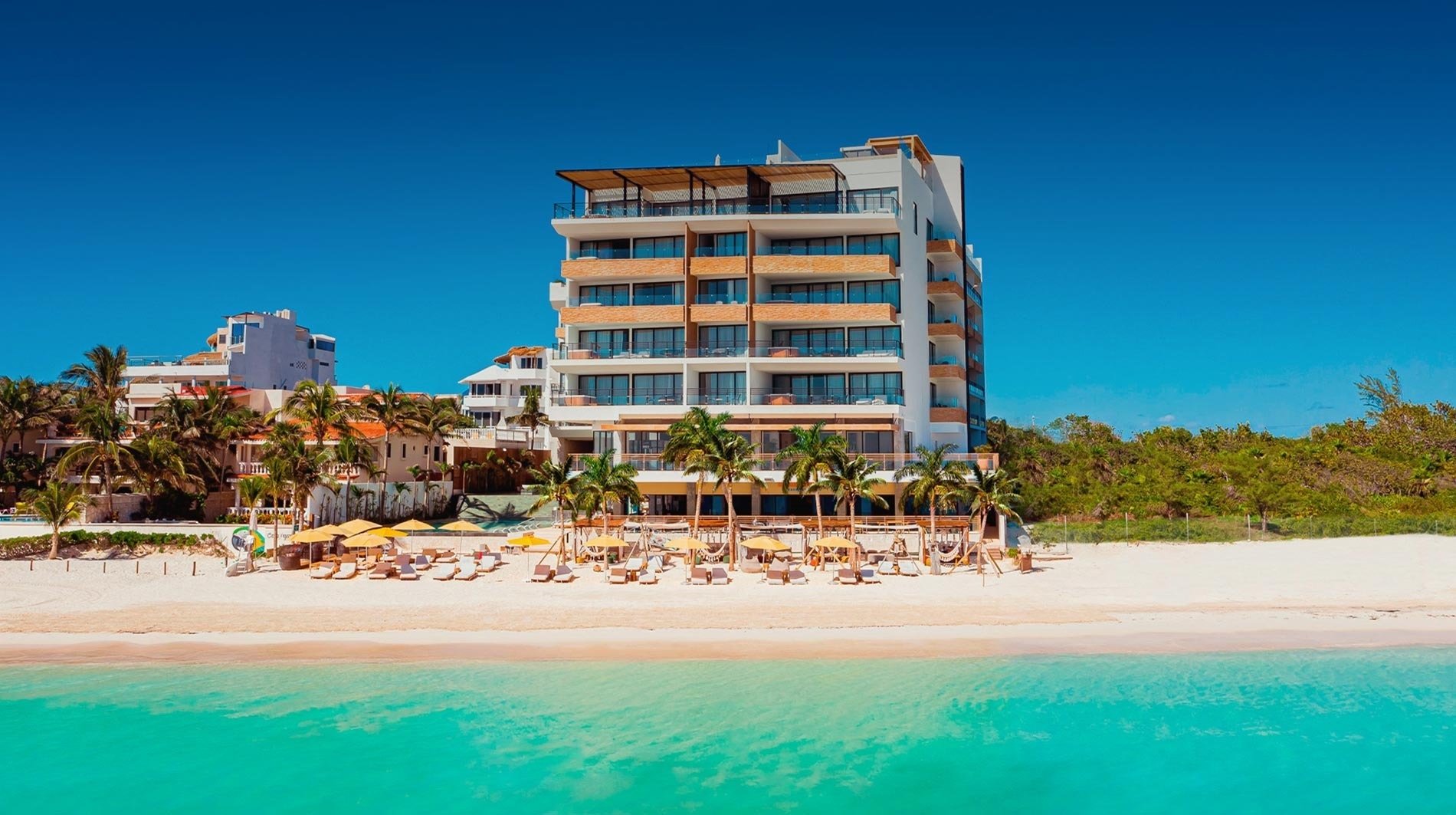 a large building with a lot of windows sits on a beach