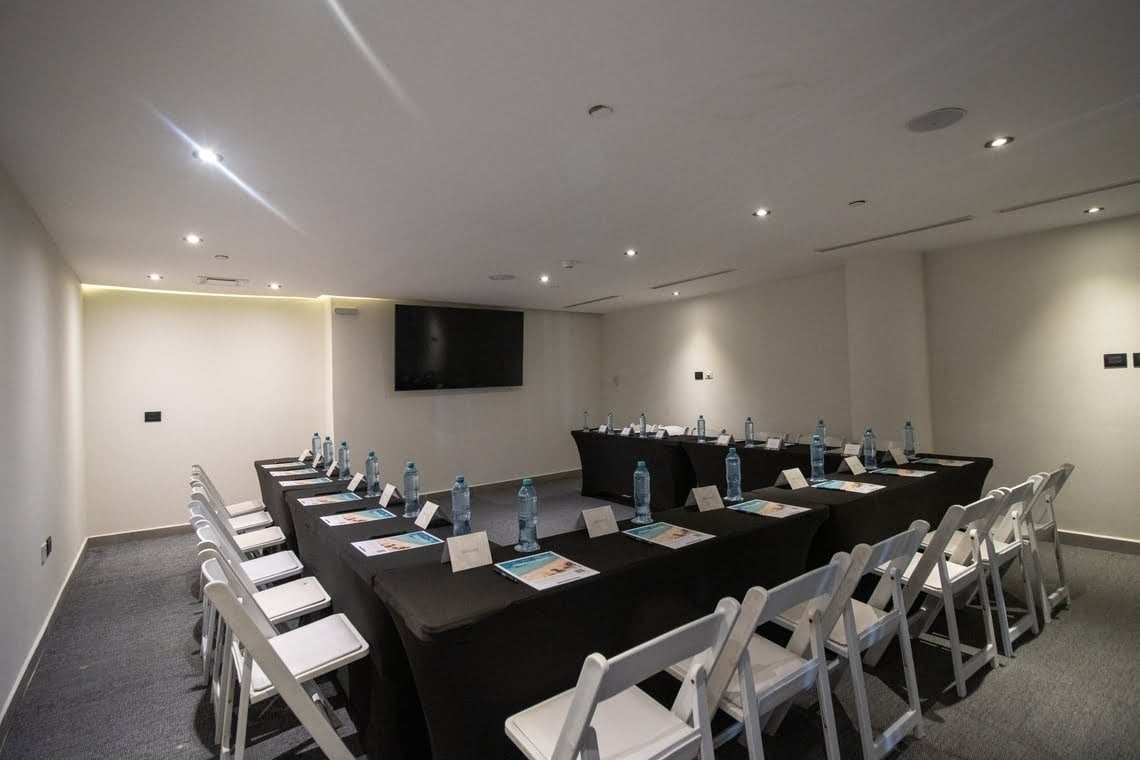 a conference room with a large wooden table and black chairs