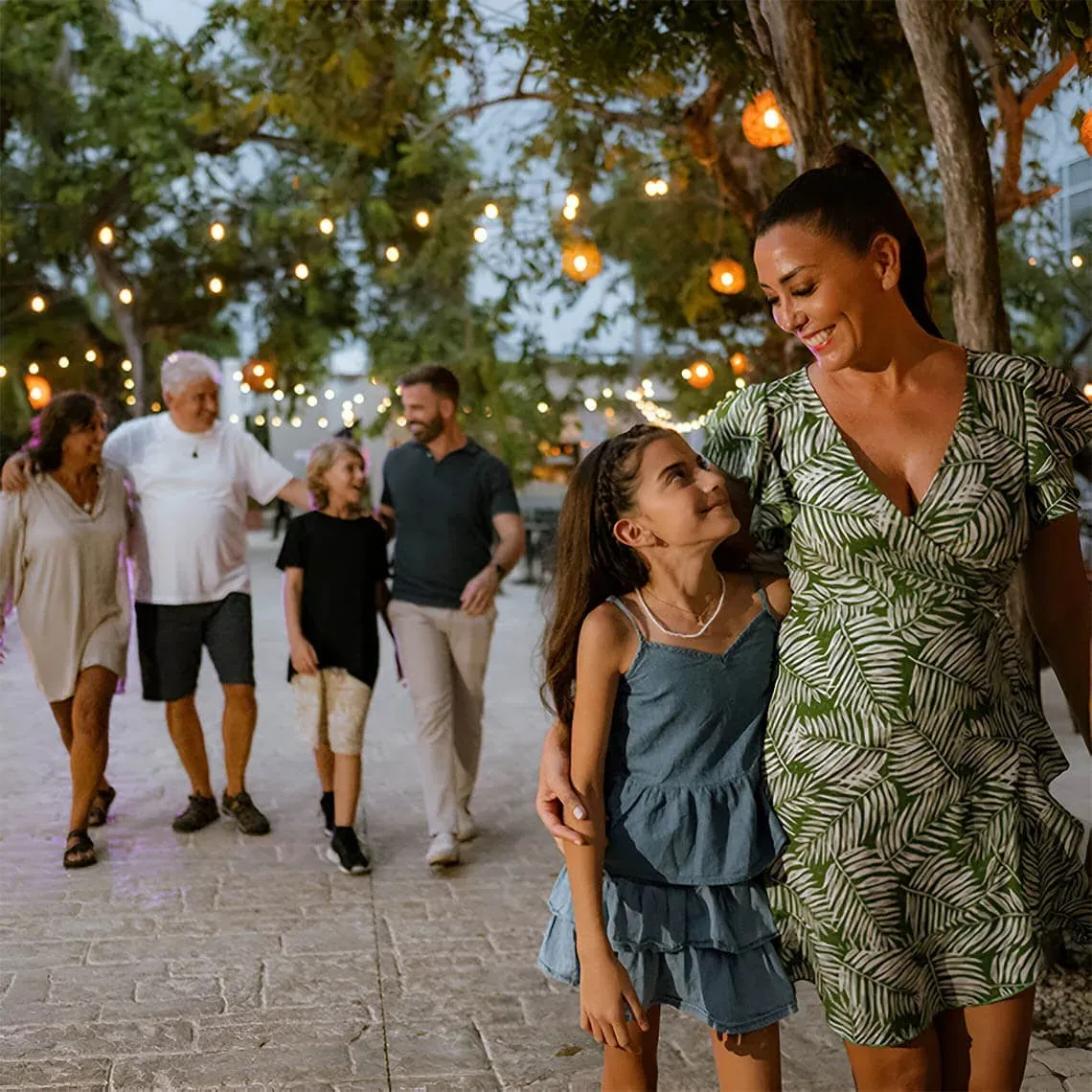 Family enjoying nighttime lights at The Fives Corpo resort.