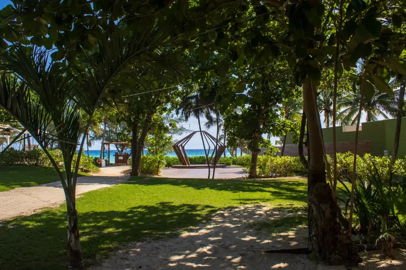 Tropical resort garden with beach view and unique sculpture. The Fives Corpo