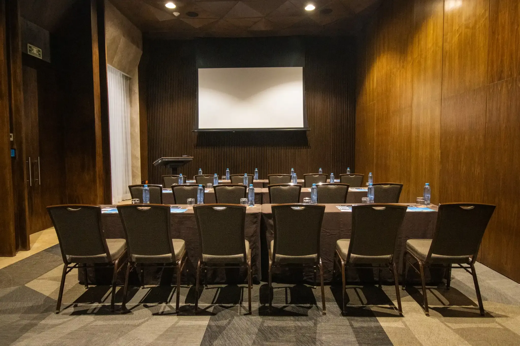 Hotel meeting room with chairs and projector screen. The Fives Corpo