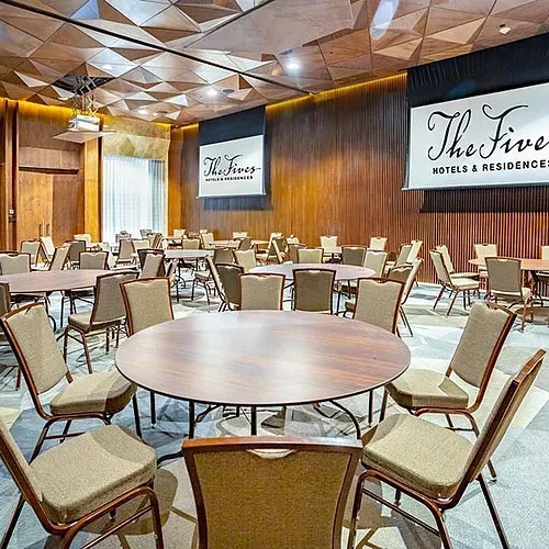 The Fives Corpo event space with round tables and chairs.