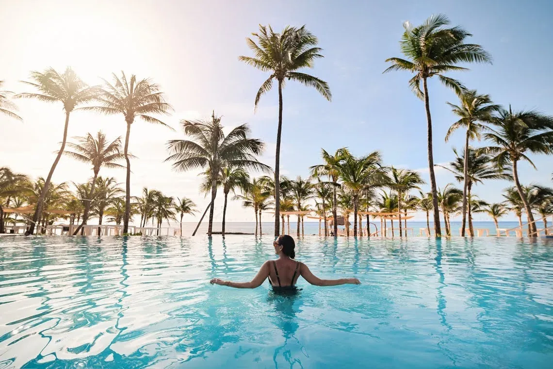 Enjoy your stay in Mexico with free eSIM: Relax in our infinity pool with palm trees.