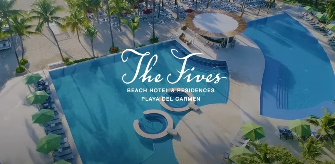 Aerial view of The Fives Corpo hotel in Playa del Carmen, featuring pools and palm trees.
