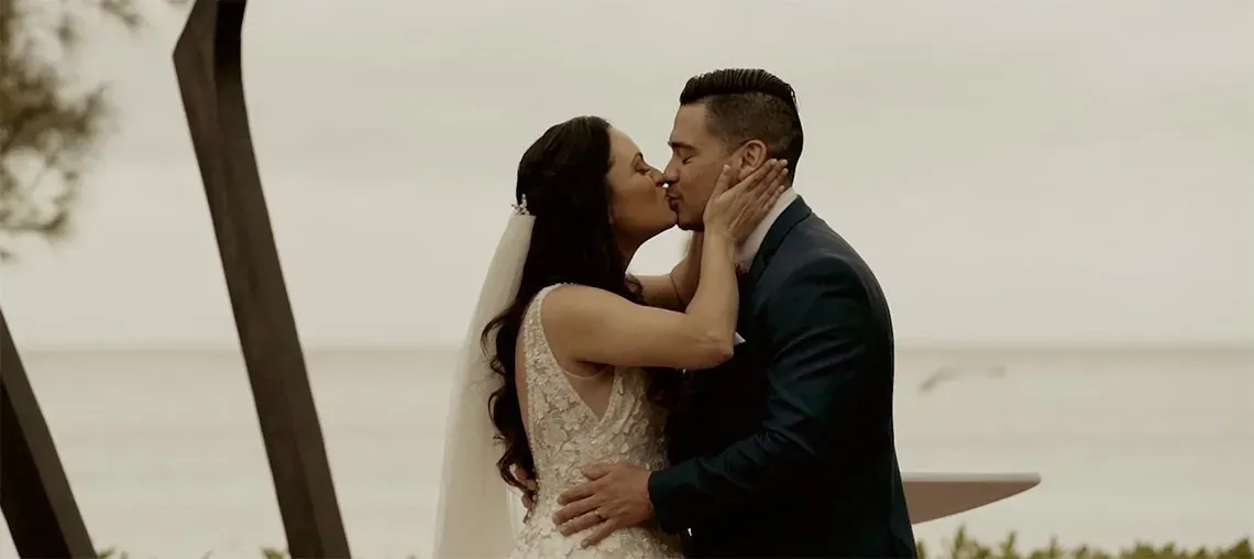 Newlyweds kissing at The Fives Corpo, seaside wedding.