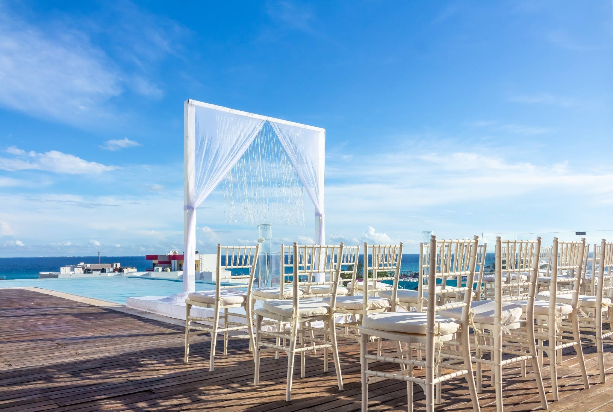 Montaje de ceremonia rooftop con detalles florales elegantes