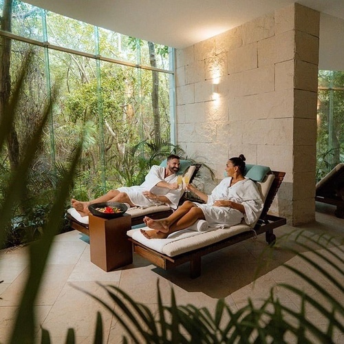 a man and a woman are sitting on lounge chairs in a spa