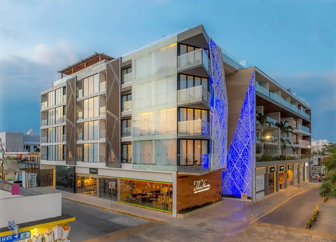 The Fives Downtown Hotel: Fachada moderna con luces azules y vistas al mar. Reserva tu estancia en México.