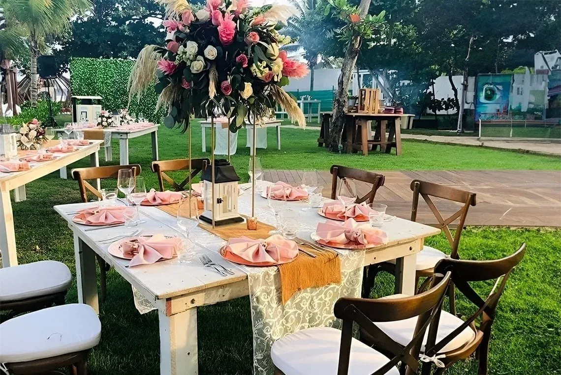 Banquete al aire libre en The Fives Corpo con mesas decoradas y flores.