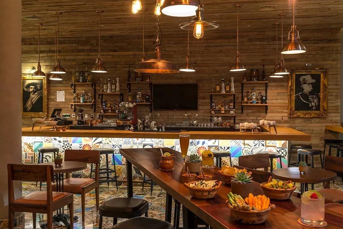 Stylish bar with decorative tiles & artwork at The Fives Downtown Hotel - Curio Collection by Hilton.